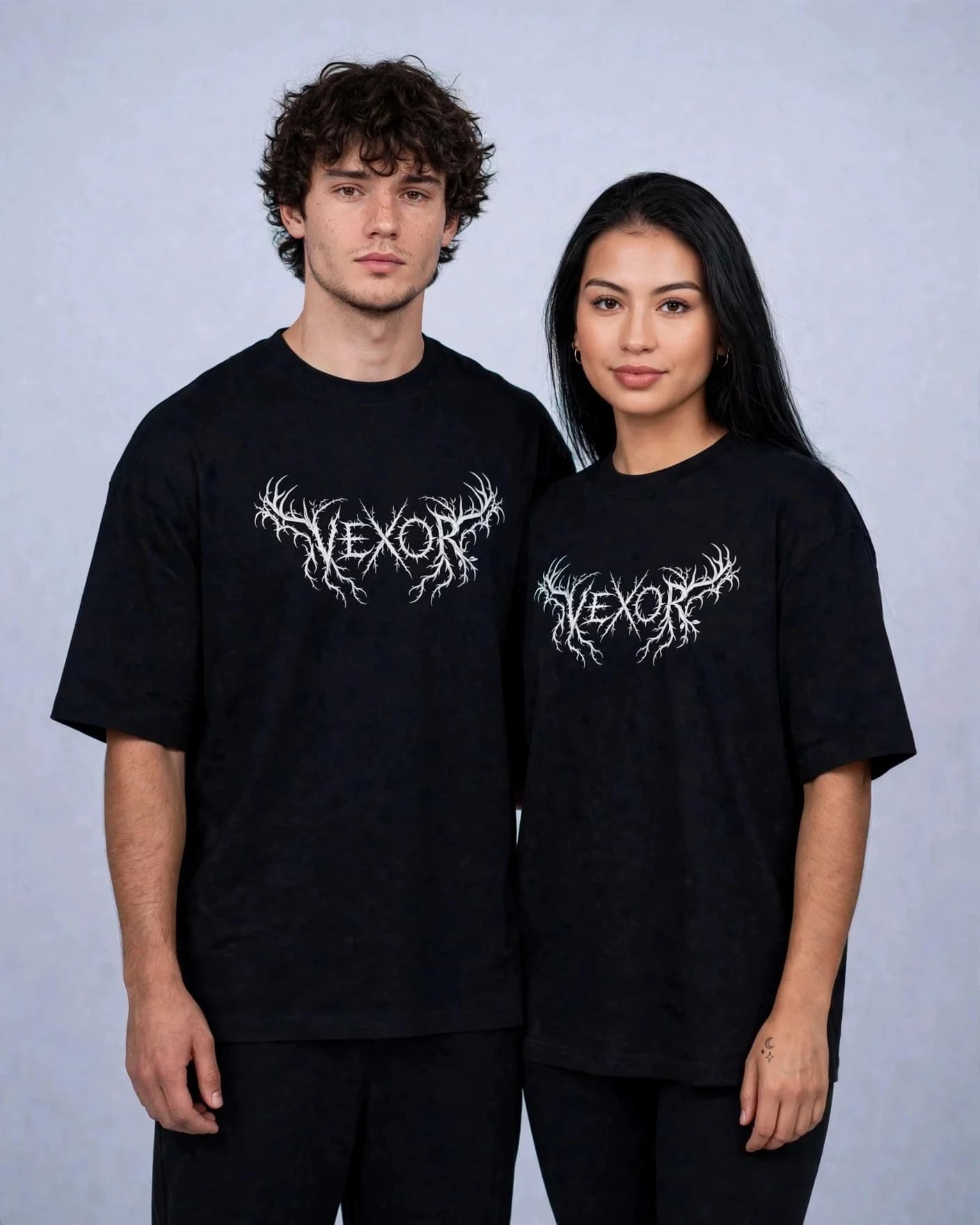 Two models in the black VEXOR metal logo oversized tee, facing the camera