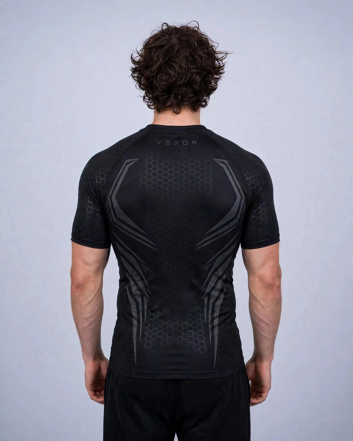 Back view of the black VEXOR Hex compression tee with dark grey armour lines and a small VEXOR wordmark under the collar