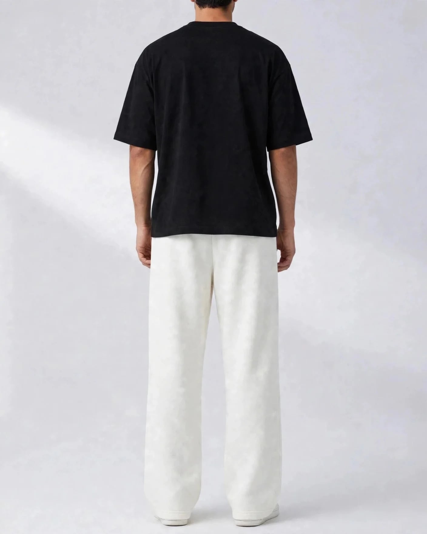 Back view of white VEXOR wide-leg sweatpants on a man, plain back