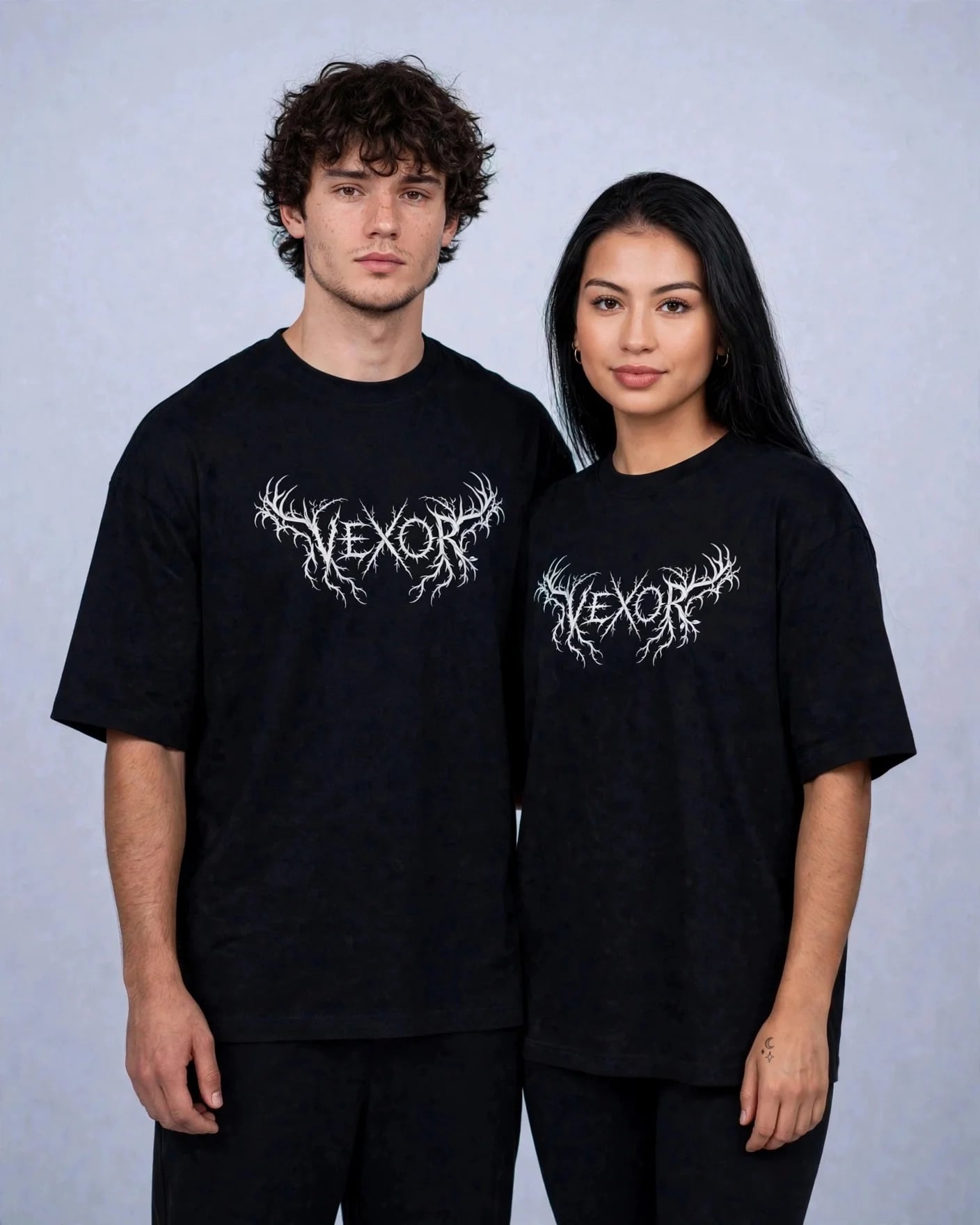 Two models in the black VEXOR metal logo oversized tee, facing the camera