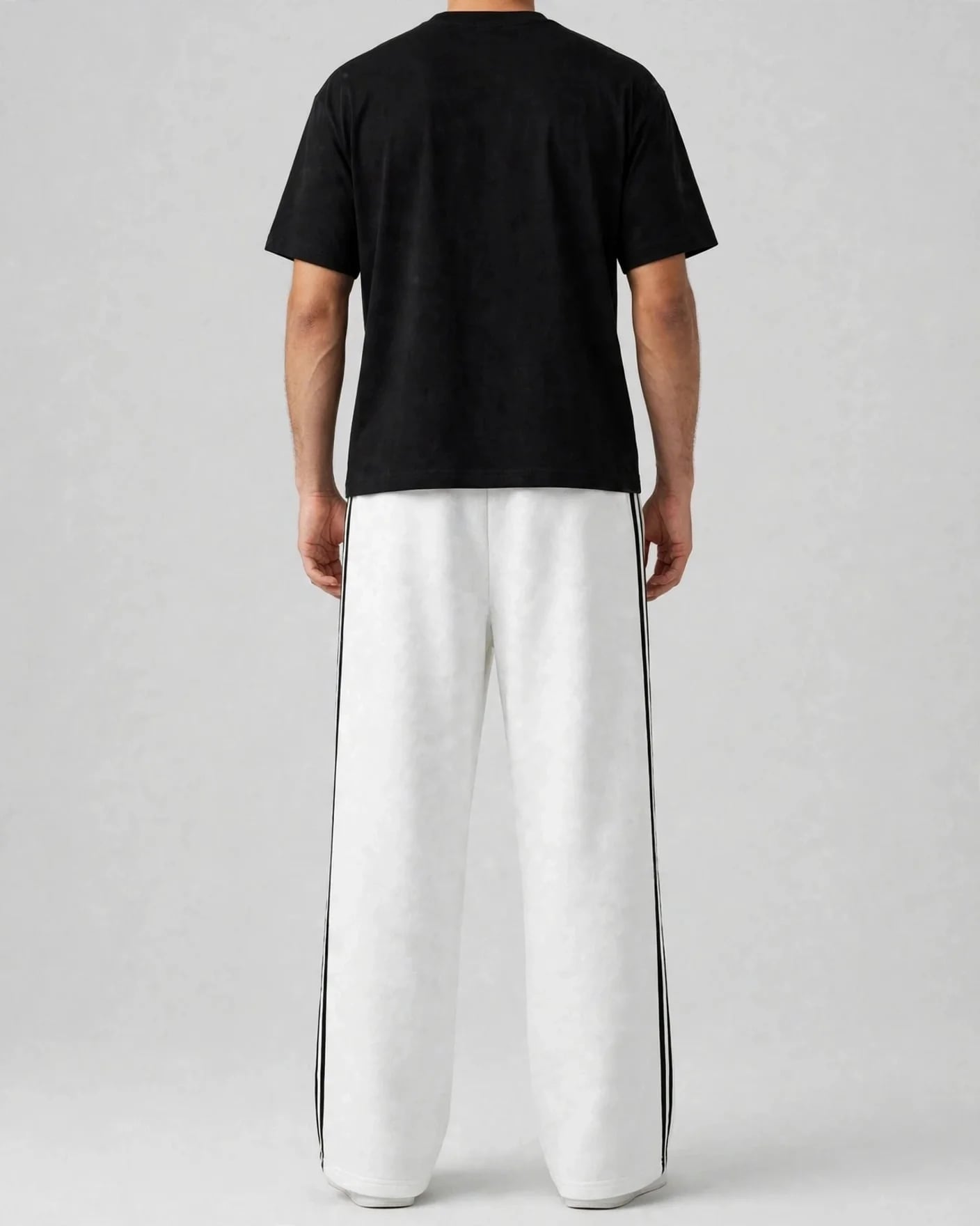 Back view of white VEXOR double-stripe wide-leg sweatpants with two black side stripes on a man, plain back