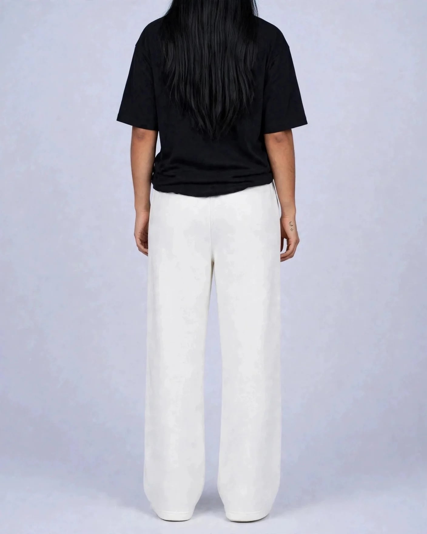 Back view of white VEXOR wide-leg sweatpants on a woman, plain back