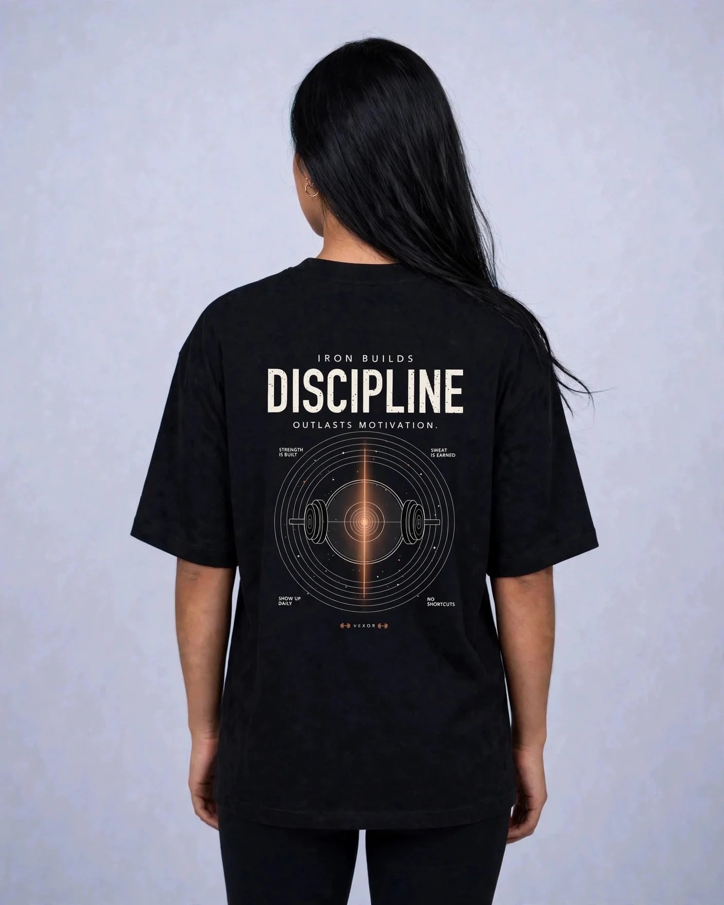 Woman wearing the black tee, back view showing the Iron Builds Discipline print