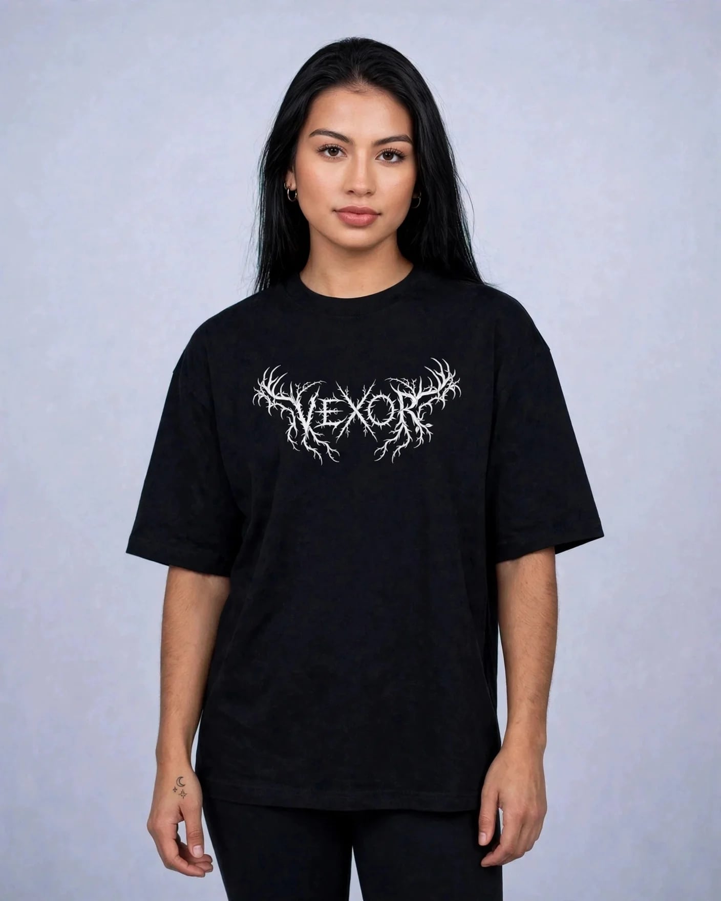 Woman wearing the black oversized tee with the white metal-style VEXOR chest logo