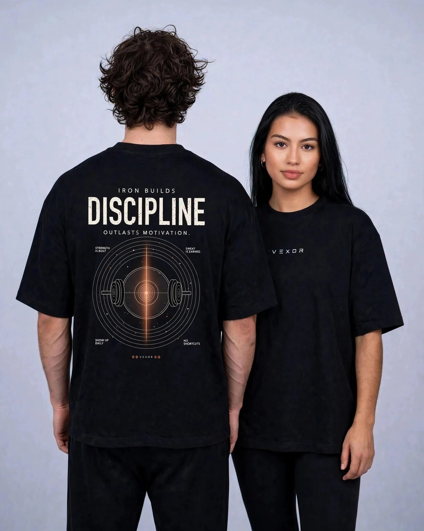 Two models in the black Iron Builds Discipline oversized tee: one showing the back print, one showing the VEXOR chest logo